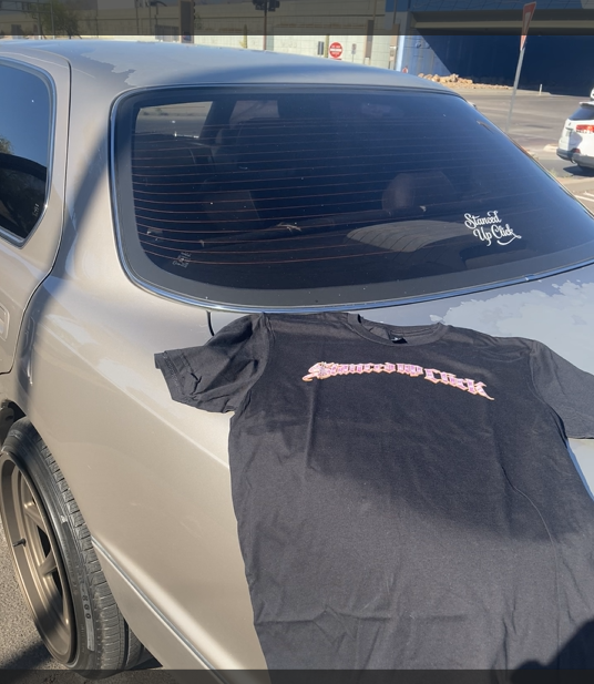 SUC Worldwide Enlighten The World Tee - front script logo on car