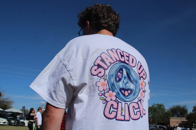 Back of the SUC Worldwide Cherry Blossom Limited Edition Tee in white, showing a chrome tri-spoke wheel framed by pink cherry blossoms and Stanced Up Click lettering